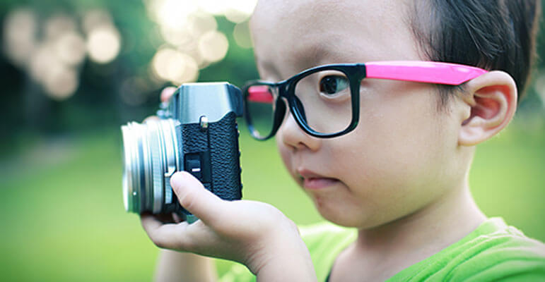 kid looking at a camera with glasses on